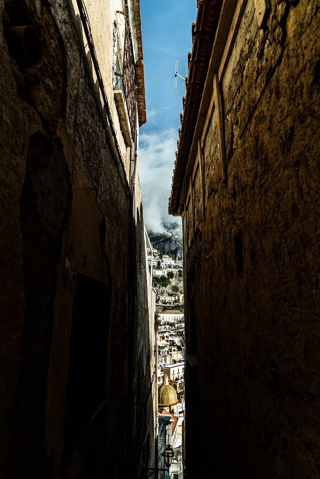 Narrow alley overlooking rooftops of an old coastal city