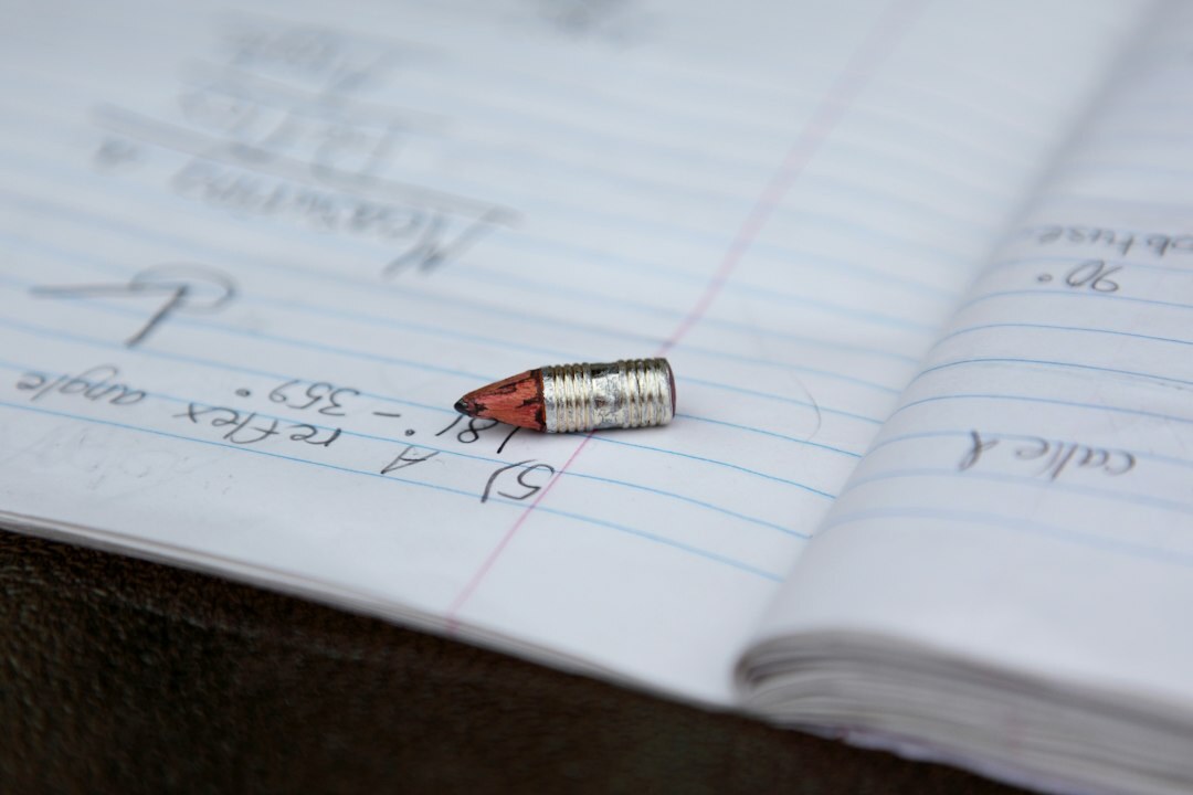 Open notebook and pen on a wooden desk with a coffee cup